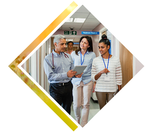 3 colleagues talking about a chart coming out of an exam room.